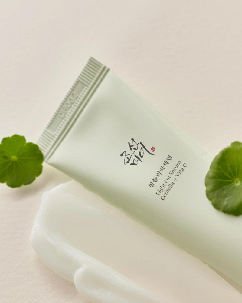 Skincare product with green leaves on a light background