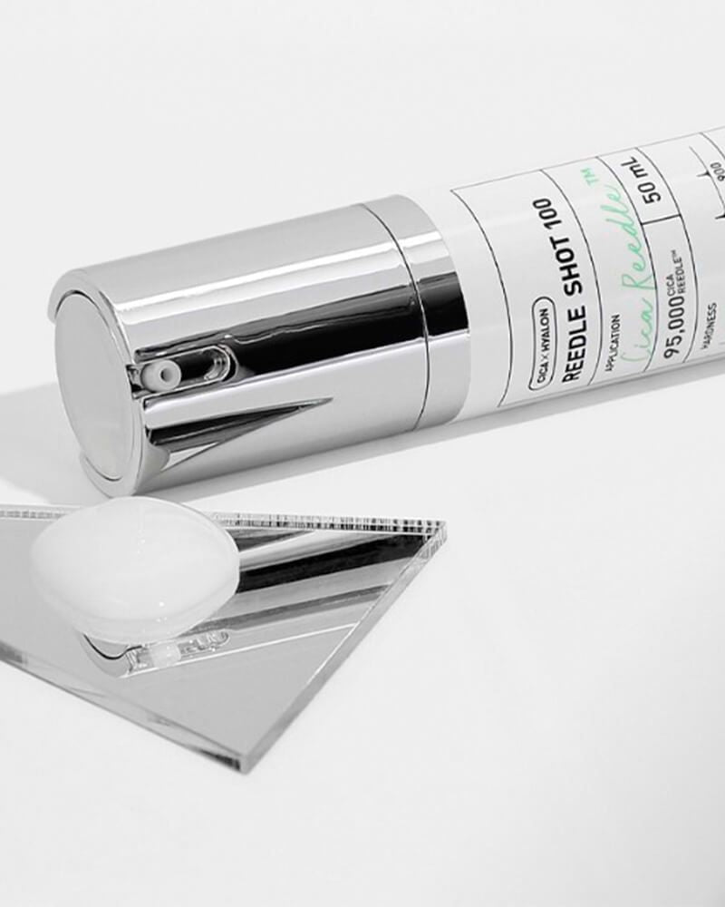 Skincare serum bottle with needle and syringe on a white background